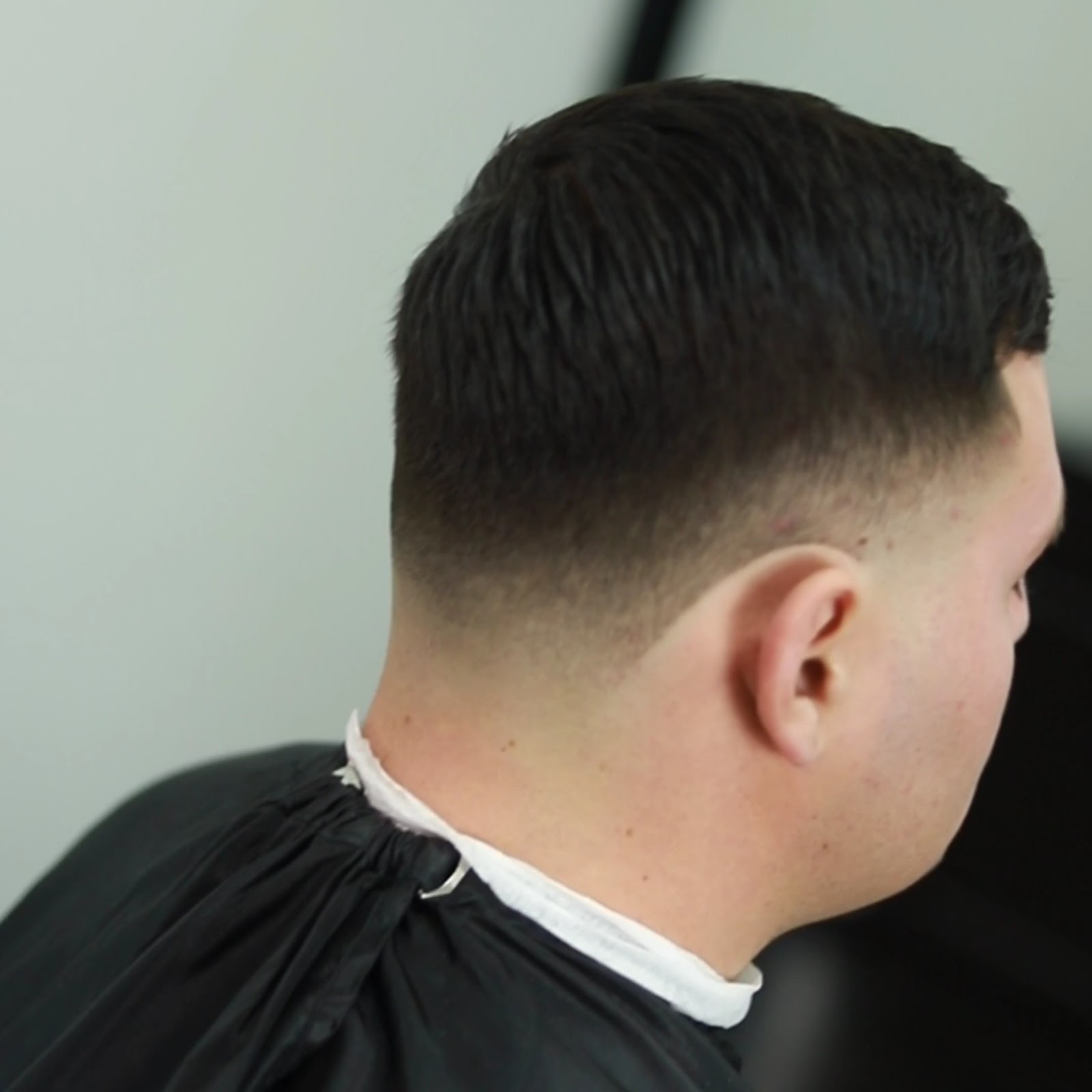 Low skin fade blended clean, white neck strip still on