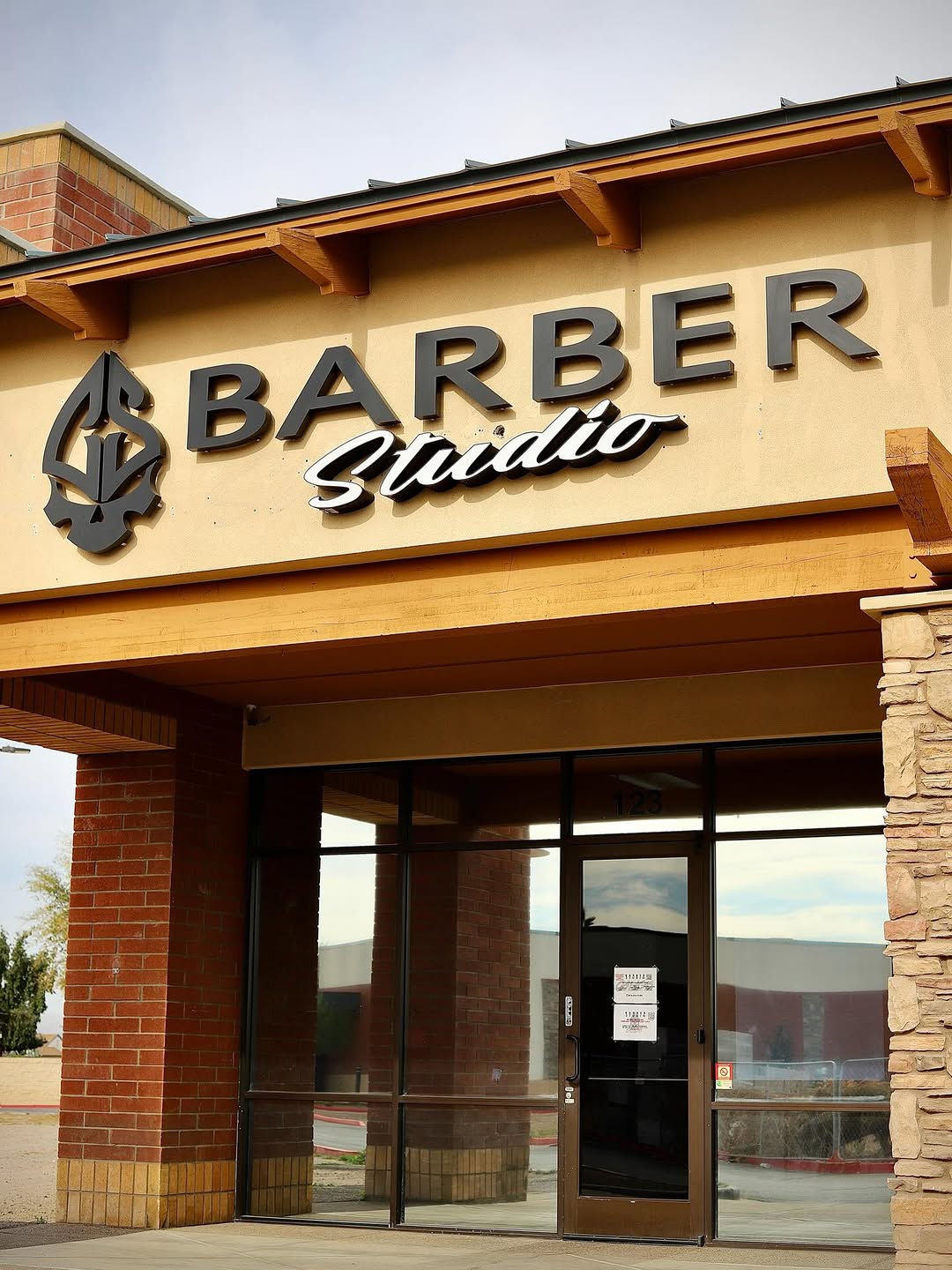 Our new storefront sign over suite 123, the calaca logo beside the words Barber Studio